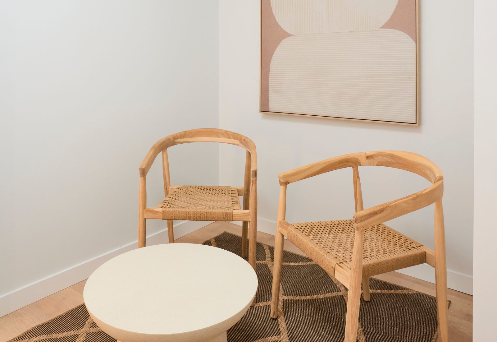 Zona de espera de GEN Yoga con dos sillas de madera y una mesa redonda